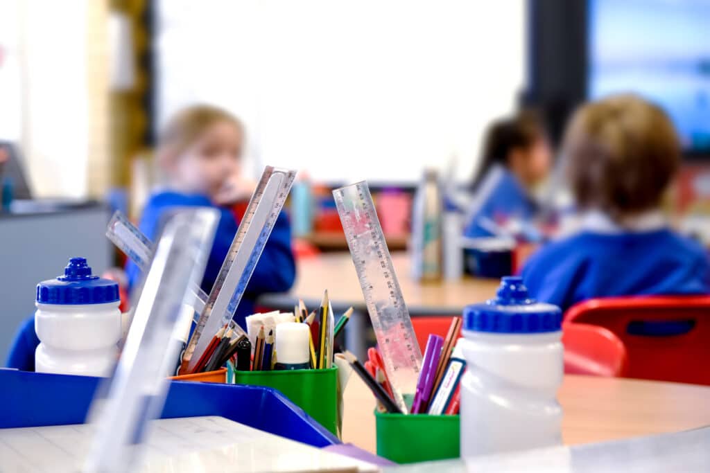 School classroom scene with kids learning in background