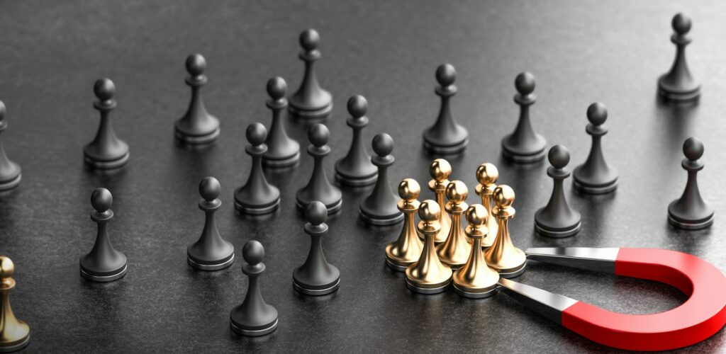 Horseshoe magnet attracting golden pawns over black background. Concept of inbound recruiting and attracting talents to the enterprise. 3d illustration.