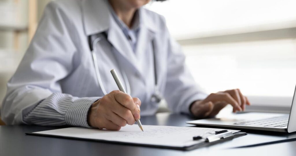 close up older female doctor working in clinic office.