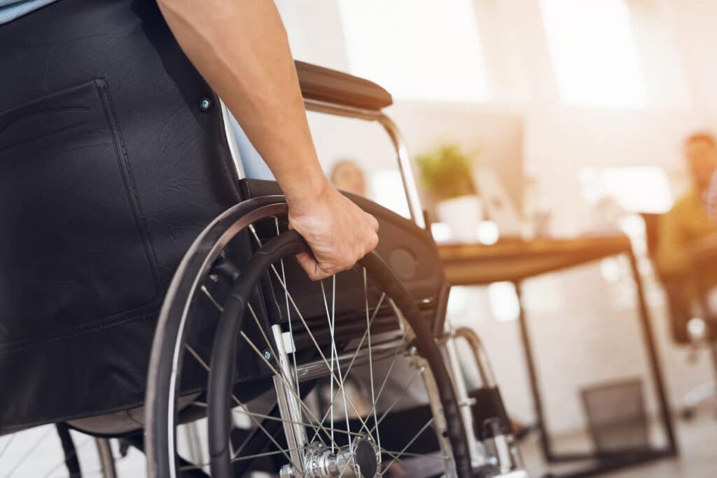 a disabled man is sitting in a wheelchair.