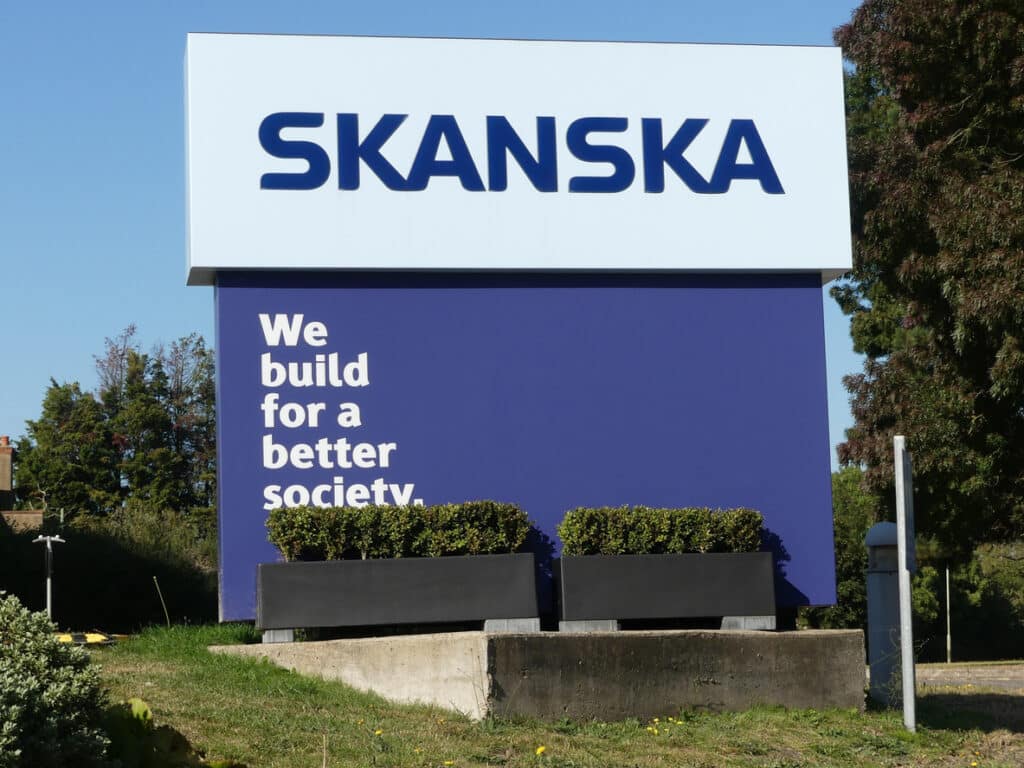 sign outside multinational construction and development company skanska's uk head office reading we build for a better society.