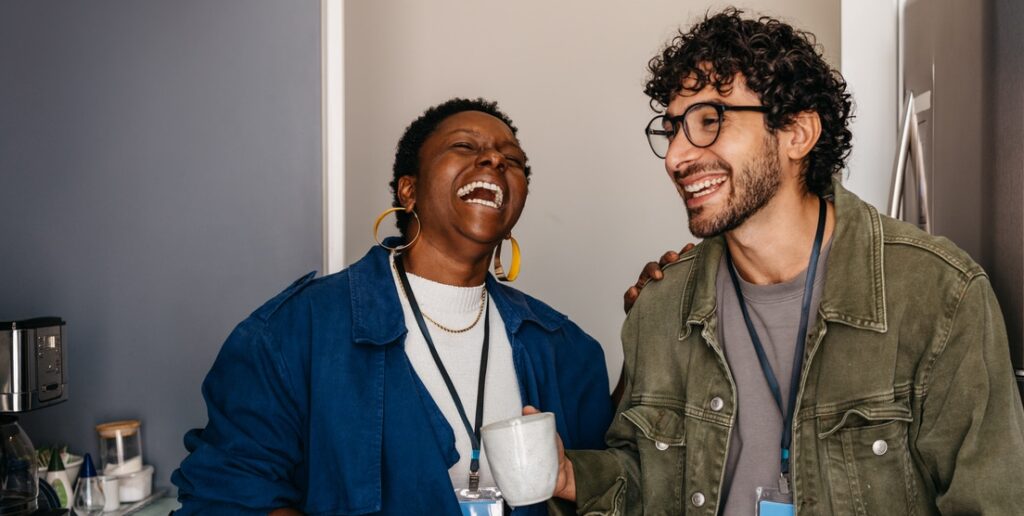 candid moment: employees at work sharing a joyful coffee break in the office, fostering friendship and laughter